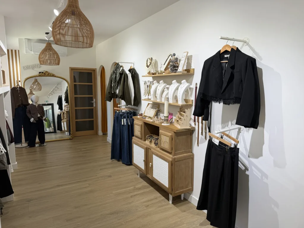 Vue d’ensemble de la boutique Atelier Mère & Fille au Houlme : portants de vestes, jeans et miroir