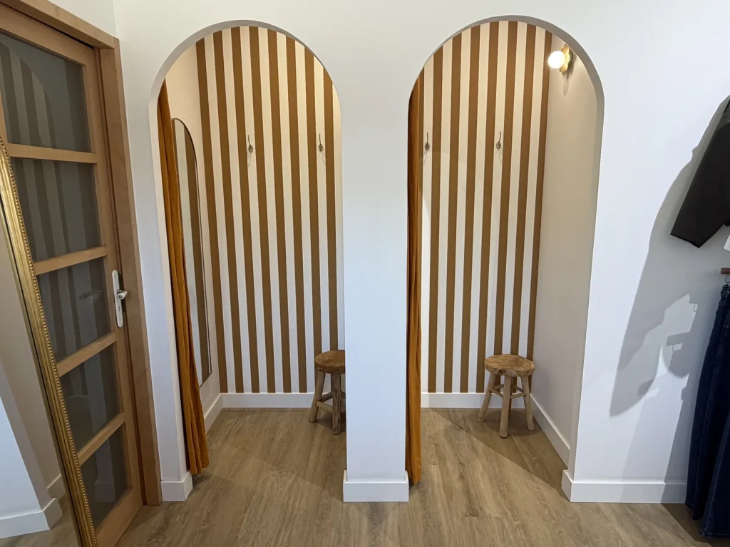 Les deux cabines d’essayage en arches de bois clair de la boutique du Houlme
