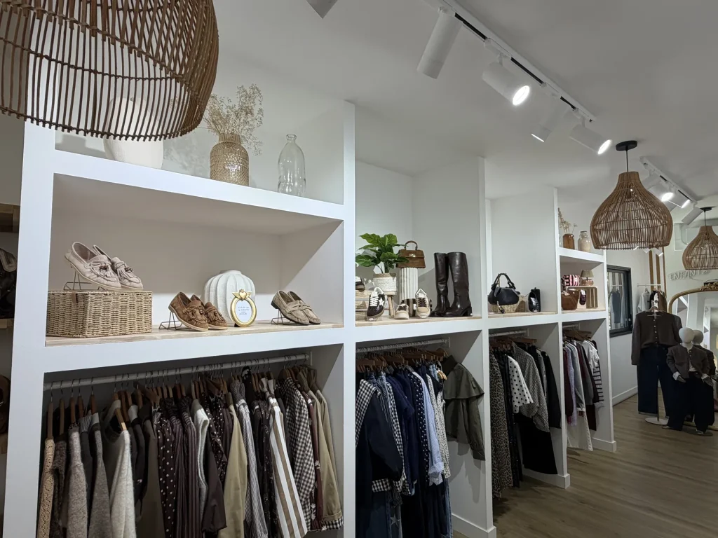 Le rayon de prêt-à-porter féminin du Houlme : étagères d’accessoires et longs portants