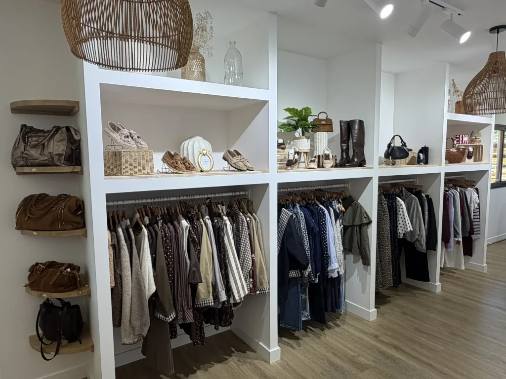 Étagères de sacs et de chaussures au-dessus des portants de la boutique du Houlme